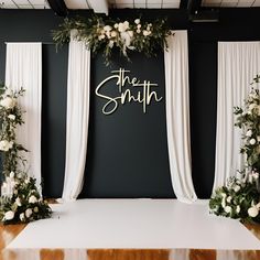 the wedding stage is decorated with white flowers and greenery