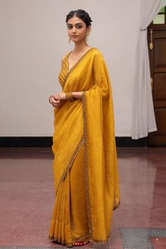 Gold yellow woven saree with sequin embroidery on border. Comes with unstitched blouse piece.
Components: 2
Pattern: Embroidered, Woven
Type Of Work: Sequin
Fabric: Munga Silk 
Color: Gold, Yellow
Other Details: 
Texture detailing
Model height: 5ft 7inches, wearing size S
Length: 5.5 m
Note: The stitched blouse worn by the model is not for sale
Occasion: Puja - Aza Fashions Festive Bollywood Pre-draped Saree In Chanderi, Elegant Yellow Saree For Transitional Season, Chanderi Pre-draped Saree For Festive Occasions, Festive Chanderi Pre-draped Saree, Art Silk Saree For Reception During Navratri, Yellow Bollywood Pre-draped Saree, Elegant Yellow Pre-draped Saree For Festive Occasions, Chanderi Pre-draped Saree With Mirror Work, Eid Chanderi Pre-draped Saree With Mirror Work