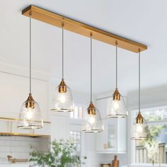 three lights hanging from the ceiling in a kitchen