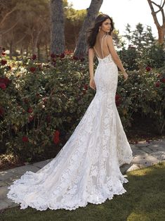 a woman in a wedding dress standing on the grass