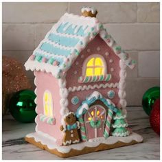 a pink and white gingerbread house with lights on