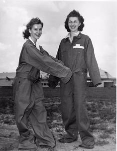 two women standing next to each other holding hands