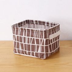 a brown and white basket sitting on top of a wooden table