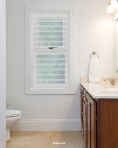 a bathroom with a sink, toilet and window