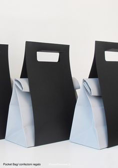 three black and white paper bags sitting on top of each other