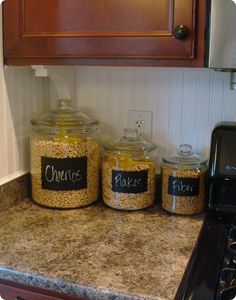 three jars filled with food sitting on top of a counter