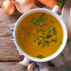 a white bowl filled with soup and garnished with herbs