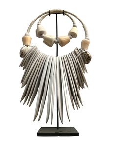 Handmade ceremonial Papua traditional Ornament from Indonesia. Made of white Shells . This Necklace is used in Papua for special rituals or ceremonies. Also is used as a payment between tribes. This beautiful piece is a very unique and powerful object in the Balinese culture. Size : Width 28 cm x 48 cm high Stature on its stand : 48 cm It can be wearied or used as a Decoration. You can buy with black metal stand You can buy without stand, you can hang it on the wall. Handmade White Jewelry For Traditional Ceremonies, White Artisan Necklace With Wooden Beads, Artisan White Necklace With Wooden Beads, Spiritual White Necklace For Rituals, Spiritual White Necklaces For Rituals, Ceremonial White Artisan Jewelry, White Artisan Jewelry For Ceremonial Occasions, White Bohemian Necklaces For Rituals, White Artisan Jewelry For Festivals