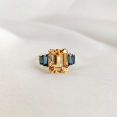 This stunning ring is set in 14k Solid Yellow Gold with Natural Citrine and London Blue topaz with utmost precision. It is an unique statement gemstone ring for nearly every occasion and is completely hassle-free jewelry.  ITEM DETAILS: * Center Gem: Citrine * Gem Size: 8X10mm * Gem Shape: Octagon  * Side Gem: London Blue topaz * Gem Size: 5x2.5mm (2pcs) & 4x2mm (2pcs) * Gem Shape: Baguette * Total Gem weight: 4.90 carats * Gold Purity: 14KT  * Gold Weight: 1.61 gram  * Total Weight of the Ring : 2.59 gram The Gold purity is guaranteed and it comes with authentic 14KT gold hallmark. Since my items are handmade, they are absolutely nickel and lead free. CUSTOMIZATION:  * Size Customization is available for this ring and it is available in all ring sizes. Kindly choose your ideal ring size f London Blue Topaz Jewelry, November Birthstone Ring, Blue Topaz Jewelry, Handmade Jewelry Box, Topaz Jewelry, London Blue Topaz Ring, Citrine Ring, Natural Citrine, November Birthstone