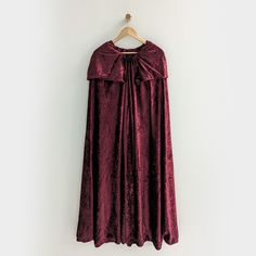 These hooded cloaks are a perfect costume accessory for anyone dressing up as a witch or Sanderson Sister. Each cape comes with a custom hood with collar and is fastened by a black metal clasp. These capes are made from polyester crushed velour and come in 3 sizes.Sizing:Youth - 30" length (3-10 years old) Adult - 46" length (13+) Adult - 56" length (13+) Care: These cloaks are made from 100% polyester velour fabric. They can be washed with like colors on gentle cycle and tumbled dried on low he Fantasy Cape For Halloween Costume, Fantasy Halloween Costume Cape, Hooded Gothic Cape For Costume, Vampire Cape For Halloween Cosplay, Gothic Hooded Cape For Costume, Witchy Halloween Cosplay Outerwear, Halloween Fantasy Event Costume Cape, Vampire Cape For Winter Costume Party, Vampire Style Cape For Halloween Costume