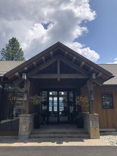 the front entrance to a lodge on a sunny day with blue skies and clouds in the background