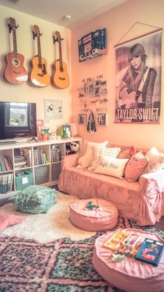 a living room filled with lots of furniture and guitars hanging on the wall above it