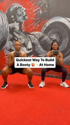 two women squatting in front of a wall with an image of a gorilla on it