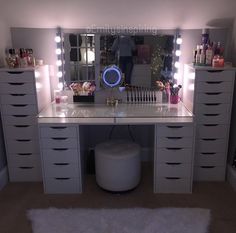 a white vanity with lights on it in a room