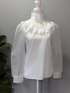 Another classic 80's remake, this time with a Victorian flare. The sheer, lace, flowered detail on the upper chest makes this piece particularly unique. Pair it with any modern blue jeans or skirt and you will definitely make a statement. Good condition, no stains or discoloration. Some small runs on both sleeves, but do not affect overall look or function due to loose, sheer material. Tag has no size, but measurements consistent with a modern US women's size S or 4-6. Please remember to take yo Classic Fitted Blouse With Sheer Sleeves, Classic Blouse With Sheer Sleeves And Fitted Design, Classic Tops With Sheer Sleeves For Party, Classic Party Tops With Sheer Sleeves, Vintage Blouse With Lace Sleeves For Parties, Vintage Party Blouse With Lace Sleeves, Vintage Tops For Fall Weddings, Vintage Lace Top With Lace Collar For Party, Fall Vintage Tops For Wedding