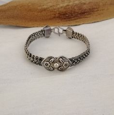 Simultaneously strong and delicate, a band in 4 strands of fine silver woven work encircles the wrist. A beautiful double heart motif carved with flowers sits centrally and is replicated at the closure. Moroccan handmade.  This bracelet is a great addition for everyday wear. Suits larger wrist size.  Weight : 29.5 Silver: stamped 925 Shipping : DHL EXPRESS 🙂 Classic Ceremonial Bracelet With Intricate Design, Classic Adjustable Bracelet With Intricate Design, Adjustable Spiritual Bracelets With Intricate Design, Adjustable Spiritual Bracelet With Intricate Design, Adjustable Sterling Silver Bangle With Intricate Design, Classic Adjustable Sterling Silver Bracelet With Intricate Design, Adjustable Bohemian Sterling Silver Bracelet With Intricate Design, Adjustable Intricate Sterling Silver Bangle Bracelet, Adjustable Bracelets With Intricate Design