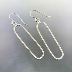 Sterling Silver line textured oval dangle earrings that measure 2 inches long and hand from Sterling Silver ear wires. They are all hand constructed by me using traditional metalsmithing techniques.  As I hand build each piece of my jewelry, I will need 7-10 days to complete your order. If you need them sooner, send me a message and I'll see if I can them done for you. Thanks so much! Jen Artisan Oval Earrings With Ear Wire, Artisan Oval Hand Forged Earrings, Hand Forged Oval Artisan Earrings, Artisan Hand Forged Oval Earrings, Minimalist Handmade Oblong Jewelry, Handmade Oval Minimalist Earrings, Handmade Minimalist Oval Earrings, Minimalist Handmade Oval Earrings, Oval Silver Wire Wrapped Earrings