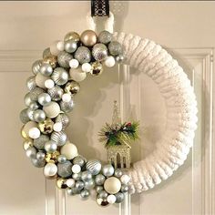 a wreath with ornaments hanging on the front door