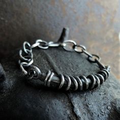 "Heavy raw silver bracelet for men. Silver 925 textured, oxidized. Main silver element: 6,7cm (2.64 in) x 1cm (0.4 in) Chain links: 1x 1,4cm (0.4\" x 0.55\") Weight at least 36g Choose your wrist circuit from the drop down menus. Please note, that the length of the bracelet is always 0.8 - 1.2 in bigger than its circuit (plus some links for adjustment). ----------------- Jewelry is packed in a jewelry box. -------------------------------" Oxidized Finish Sterling Silver Link Bracelet As Gift, Oxidized Sterling Silver Link Bracelet, Sterling Silver Oxidized Link Chain Bracelet, Sterling Silver Link Bracelet With Oxidized Finish, Sterling Silver Bracelets With Oxidized Finish And Chain Link, Bracelet For Men Silver, Unique Mens Bracelet, Silver Bracelet For Men, Bracelet Man