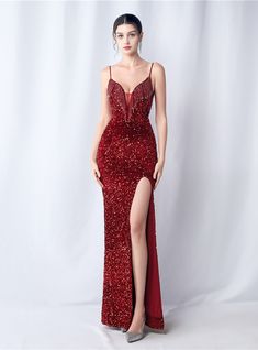 Featuring a splendor that rivals the fiercest fire, the gown is a cascade of sequins that catch every flicker of light. This prom dress is an embodiment of passion, crafted for those who command the spotlight with ease and elegance. The entirety of the dress sparkles with dense, red sequins, creating a texture thatboth visually stunning and delightful to the touch. Its fitted silhouette is complemented by the fluidity of the high slit, marrying movement with a statuesque quality. The delicate straps and refined neckline are designed to flatter, leading the gaze to the intricate detailing of the bodice. This dress doesn't just make an entrancet makes a statement of intent, one of unforgettable impact and enduring charm. Ruby Red Prom Dress, Minimalistic Accessories, Dark Green Velvet, Sequin Halter, Minimalist Accessories, Mermaid Sequin, Backless Prom Dresses, Red Prom, Red Sequin