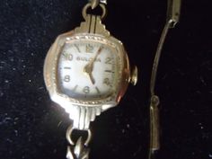 Vintage Lady Bulova, Art Deco in design.   Marked 10k Rolled Gold Plate and numbered; 8117011.  It has a clasp closure that reads: 1/20-12k G. F. Sterling base Pat.2.097.055 USA.  Winding mechanism needs repair.  Includes original which reads: Bulova, Fifth Avenue - New York.  The Goddess of Time. Item# J0171 Yellow Gold Jewelry With Gold Clasp For Evening, Evening Yellow Gold Jewelry With Gold Clasp, Antique Formal Jewelry With Gold Clasp, Formal Engraved Yellow Gold Jewelry And Watches, Hallmarked Yellow Gold Jewelry And Watches As Gift, Art Deco Yellow Gold Jewelry And Watches For Gift, Heirloom Yellow Gold Jewelry And Watches For Collectors, Art Deco Jewelry And Watches As A Gift, Art Deco Jewelry And Watches As Gift