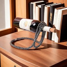 a bottle of wine sitting on top of a wooden table next to a book shelf