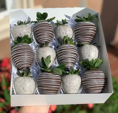 chocolate covered strawberries in a white box with green leaves on the top and bottom