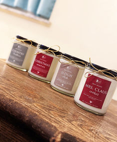 three jars of candles sitting on top of a wooden table