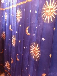 the shower curtain has sun and moon designs on it, along with stars and crescents