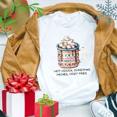 a white t - shirt that says hot cocoa christmas movies cozy frees on it