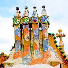 an elaborately designed building with colorful decorations on it's roof and windows in front of a cloudy blue sky