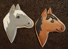 two decorated cookies shaped like horses on a table