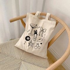 This 100% cotton tote bag is perfect for everyday wear. It's durable and will last for years. The bag features 20" handles (made from the same canvas), making it easy to carry even with a week's worth of shopping. * 100% cotton canvas * Heavy fabric Sizing: * 15 inches x 16 inches Care Instructions: * Hand wash only if needed Estimated Delivery Times:  Canada:  * Standard: 4-16 days  USA:  * Standard: 4-16 business days * Economy: 4-8 business days  International: * Standard: 10-30 business days Minimalist Coquette, Coquette Graphic, Y2k Tote Bag, Totes Ideas, Canvas Bag Design, Bag Y2k, Bag Minimalist, Printed Canvas Tote Bag, Cute Canvas