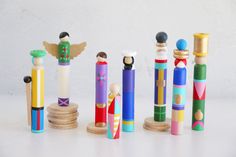 several wooden crayons are lined up on a white surface and one has an angel