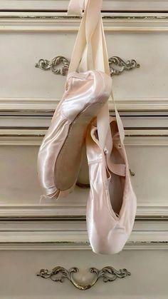 two ballet shoes hanging on a wall