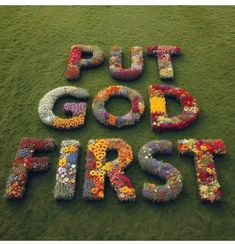 the words put god first are made out of flowers and petals on top of grass