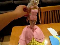 someone is decorating a barbie doll cake