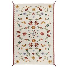 a white rug with red trim and flowers on the bottom, in front of a white background