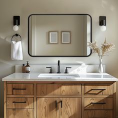 a bathroom vanity with a large mirror above it and two lights on the wall next to it