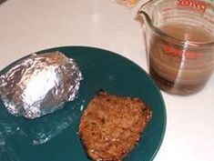 a piece of cake on a plate next to a measuring cup and glass container with liquid in it