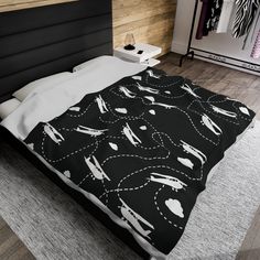 a bed with black and white comforter on top of it