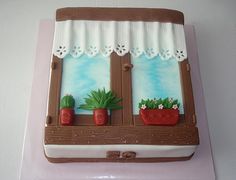 there is a cake that looks like a window with potted plants on it