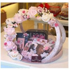 a display case filled with pink and white flowers on top of a counter next to a cake