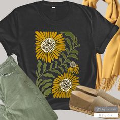 Description: Our "Sunflower Rising" design on Bella Canvas cotton Unisex T-shirt.  The American graphic tee shirt is an icon of individuality around the world. Who doesn't love a good t-shirt day? It means you get to feel comfortable wherever you're headed, while also showing off your style and personality!  Feel confident you are purchasing a quality product that is eco-friendly and produced in America. Our DTG printing is eco-friendly utilizing water based inks! Our shirt manufacturer, Bella+C Wildflower Shirt, Botanical Shirt, Shirt Tag, Original Clothes, Dtg Printing, Retro Floral, Graphic Tee Shirts, Feel Confident, Combed Cotton