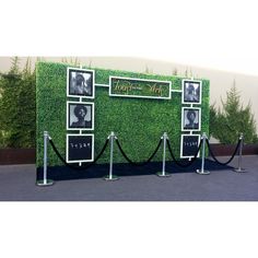 a green wall with black and white pictures on it's sides, surrounded by rope