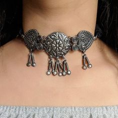 Add charm and charisma to your beautiful personality with these stunningly handcrafted choker set in antique  silver look  Earrings are also designed beautifully and compliment the choker very well. Wear it with any of your formal or casual outfits and grab compliments all the way!Length of the metal part in the choker is 4 inches  approx with a 10 inch  adjustable black chord (dori at the back)Weight of the choker 42gms Each earring weighs 10 GM's Length 1.5 inches ***************************** Vintage Silver Choker For Festive Occasions, Bohemian Choker With Intricate Design For Festivals, Heavy Silver Metal Choker, Metal Choker With Oxidized Finish, Festive Metal Choker With Intricate Design, Wedding Metal Choker With Oxidized Finish, Bohemian Oxidized Finish Choker As Gift, Traditional Silver Handmade Choker, Traditional Handmade Silver Choker