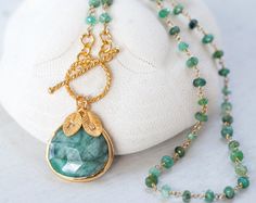 "This listing is for a beautiful bezel set Natural Raw Emerald stone in 18k gold vermeil with an 18k gold vermeil toggle clasp lariat necklace. The chain is hand wire wrapped Raw Emerald. The leaf charms are 16k gold plated base metal. Select length in the drop down menu (necklace pictured is 18 inches) ✦Please leave me a comment during checkout with the personalized letters you would like. 1 letter per leaf. Upto 4 leaves per necklace. Because I use natural stones, the stones may vary slightly Natural Stones Jewelry, Raw Emerald, Wrapped Necklace, May Birthstone, Emerald Necklace, Wire Wrapped Necklace, Leaf Charms, Lariat Necklace, Christmas Gifts For Her