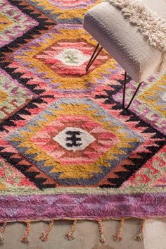 a multicolored area rug with a chair and ottoman