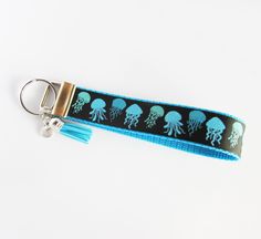 a keychain with an octopus design on it and a blue tassel hanging from the end