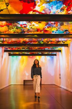 a woman standing in front of a colorful ceiling